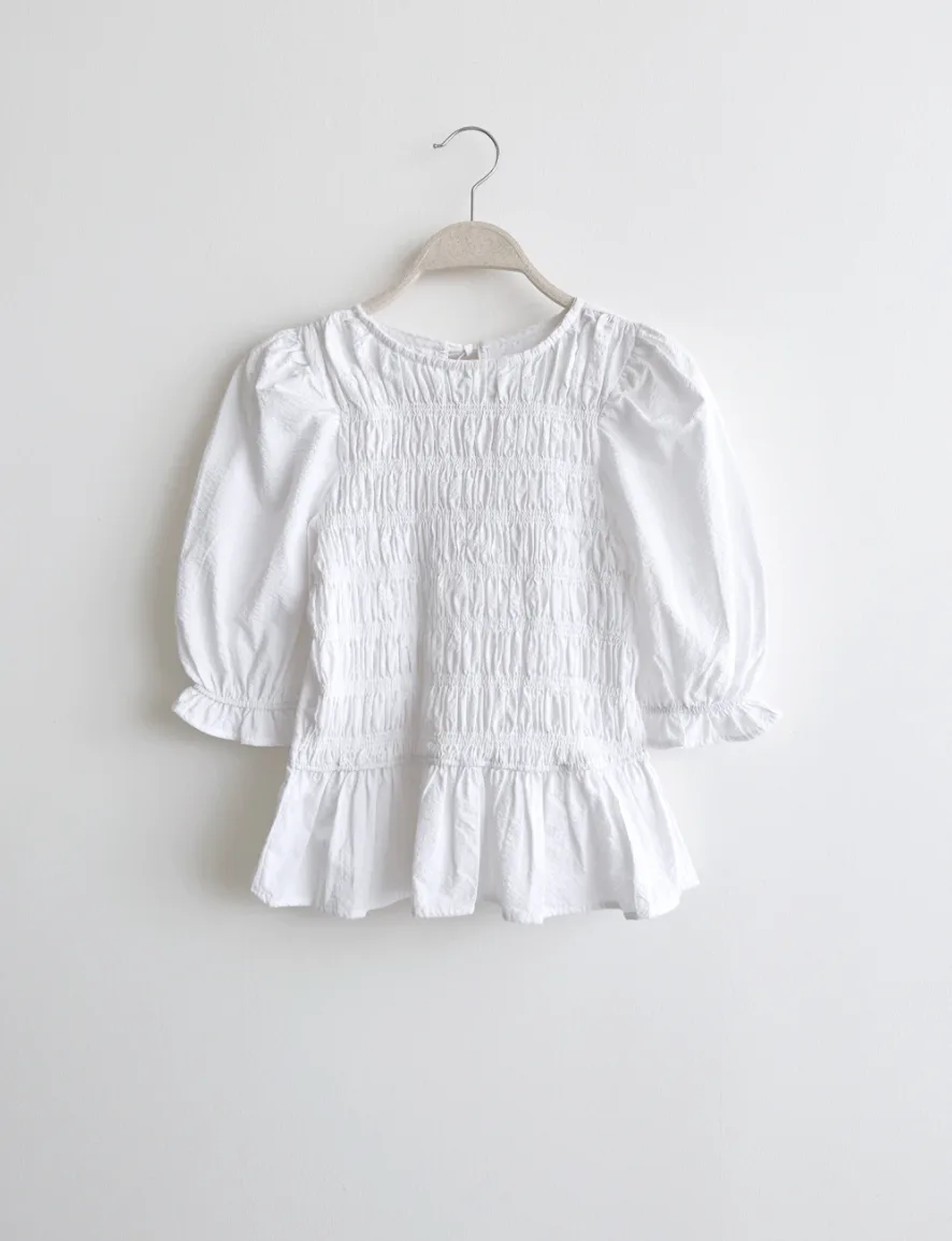 Blusa blanca con peplum en percha
