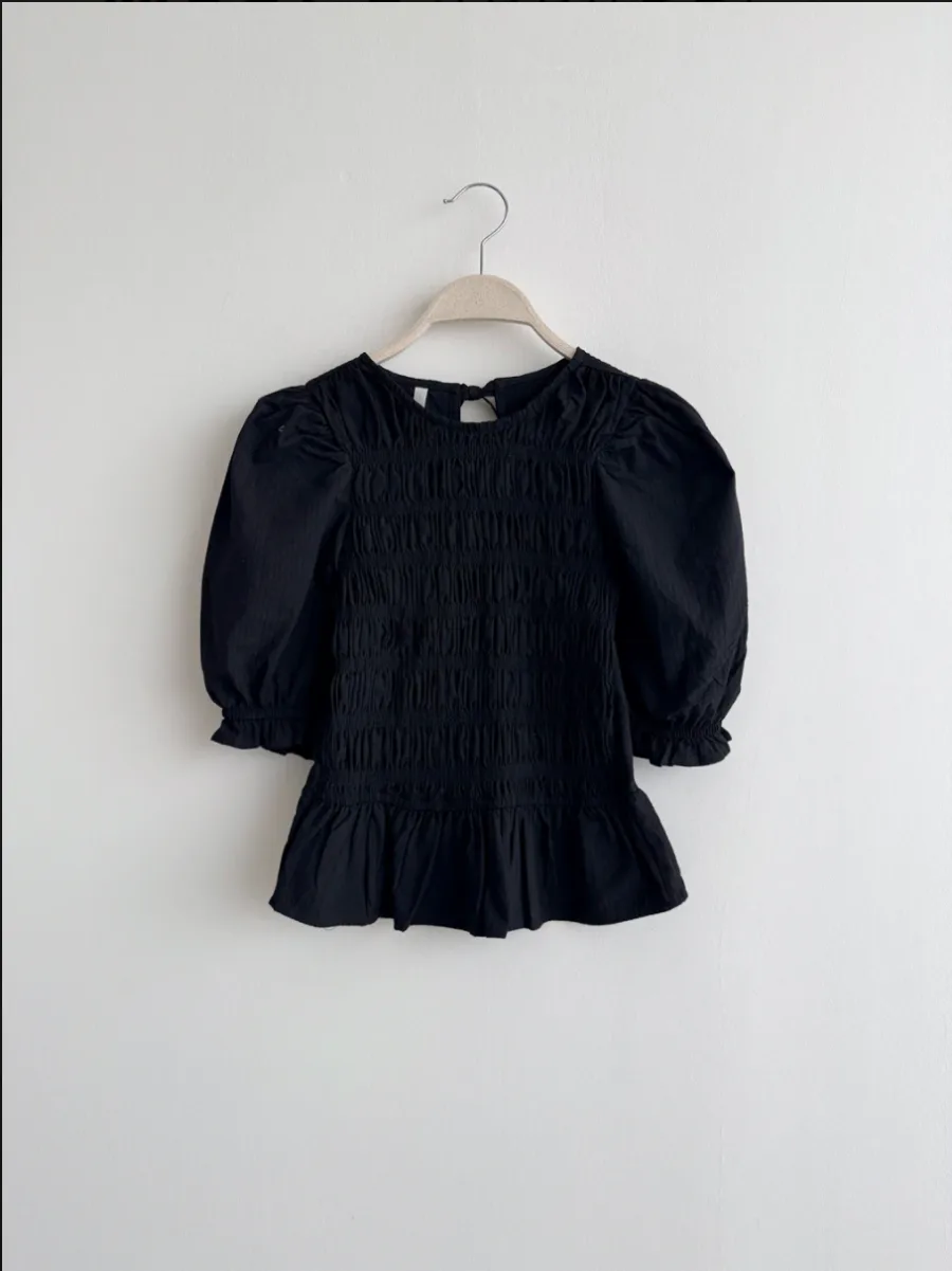 Pechera smock negra en percha